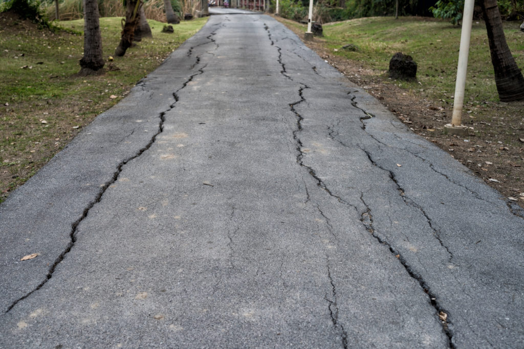 Cracked asphalt of local road.