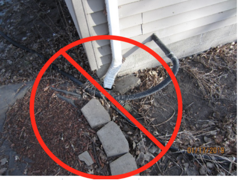 Downspout water dumping water into a foundation.