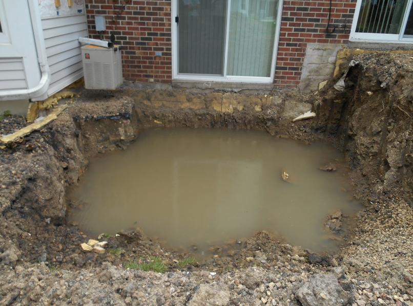 Clay soil holding massive amounts of water around this town home's foundation.