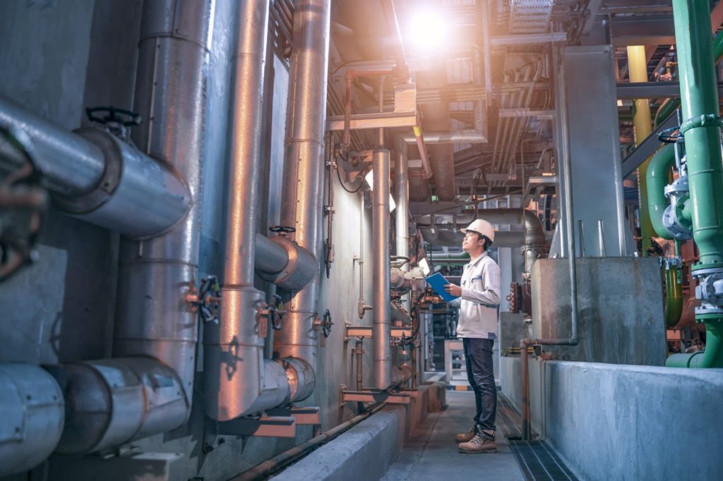 plant worker checking on steel in factory.